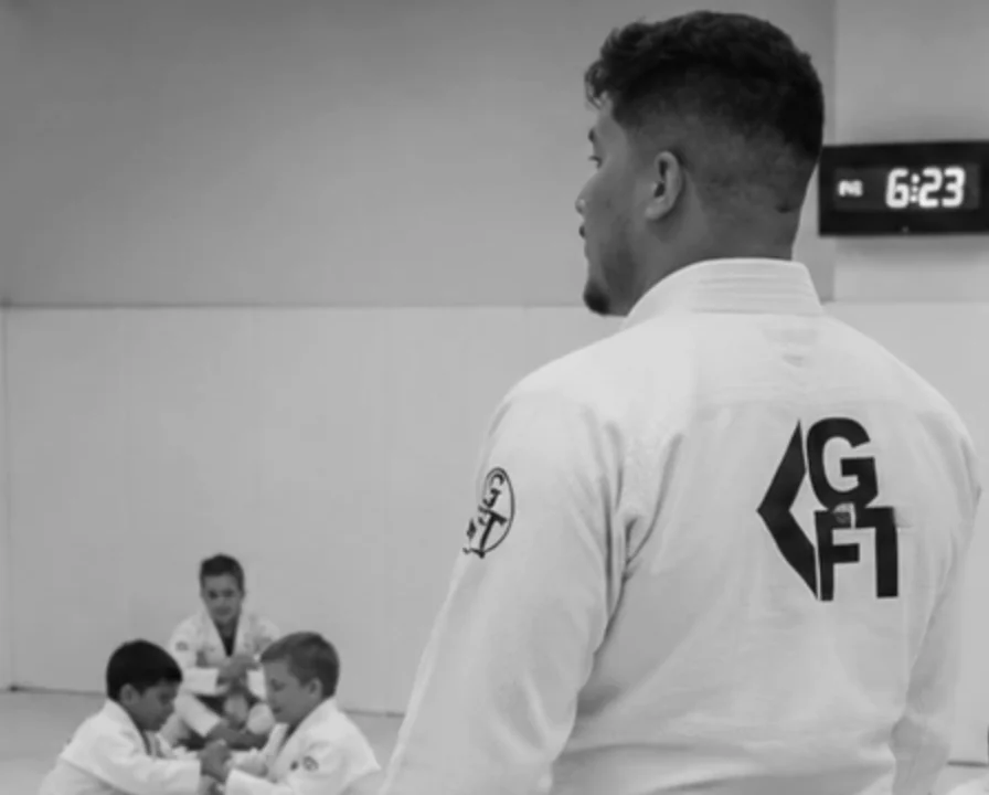 Professor Nando Carvalho in his GFTEAM gi, coaching a kids Brazilian Jiu-Jitsu class